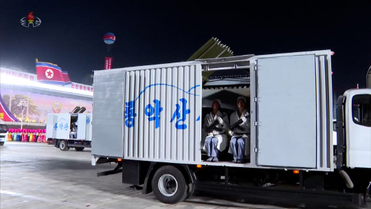 북한 조선중앙TV는 지난 8일 저녁 평양 김일성광장에서 열린 정권수립 75주년 민방위무력 열병식을 9일 녹화중계 했다. 리춘히 아나운서는 '룡악산샘물'이라고 씌여진 트럭이 행진하는 장면에서 "민간무력 위장방사포병 구분대"라고 전했다.  [조선중앙TV 화면]  연합뉴스